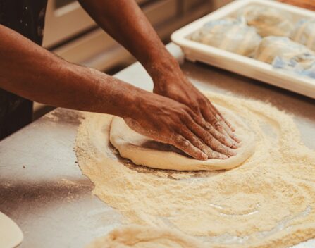 a person kneading dough on top of a table